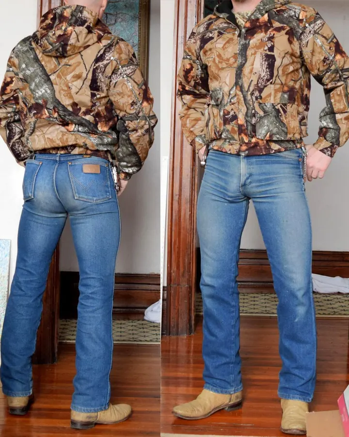 Homme de dos et de profil, vêtu d'une veste camouflage, jeans bleus, bottes marron, mains dans les poches.