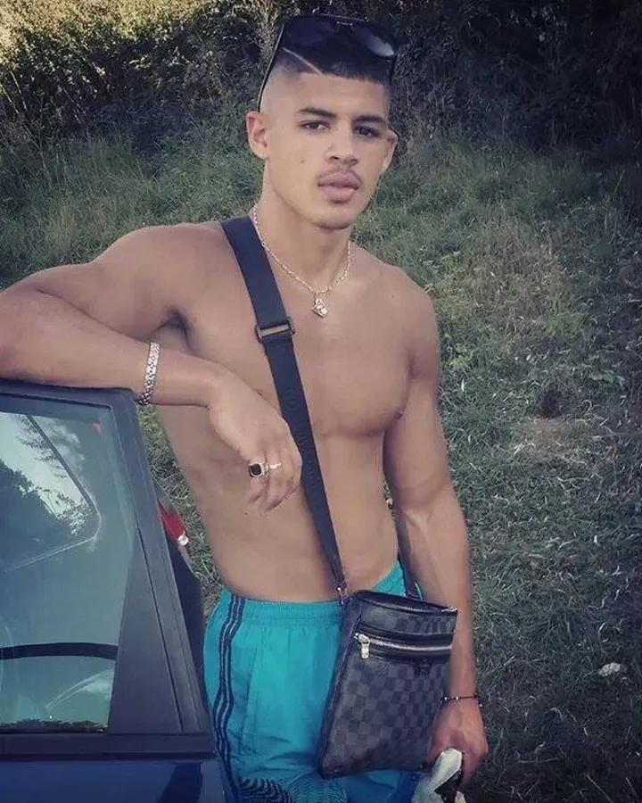 Homme torse nu, en sous-vêtements, debout près d'une fenêtre, regardant vers l'appareil photo, dans une ambiance naturelle et douce.