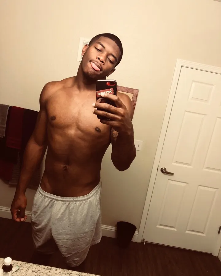 Homme torse nu, regardant l’appareil, main dans les cheveux, ceinture noire, jeans