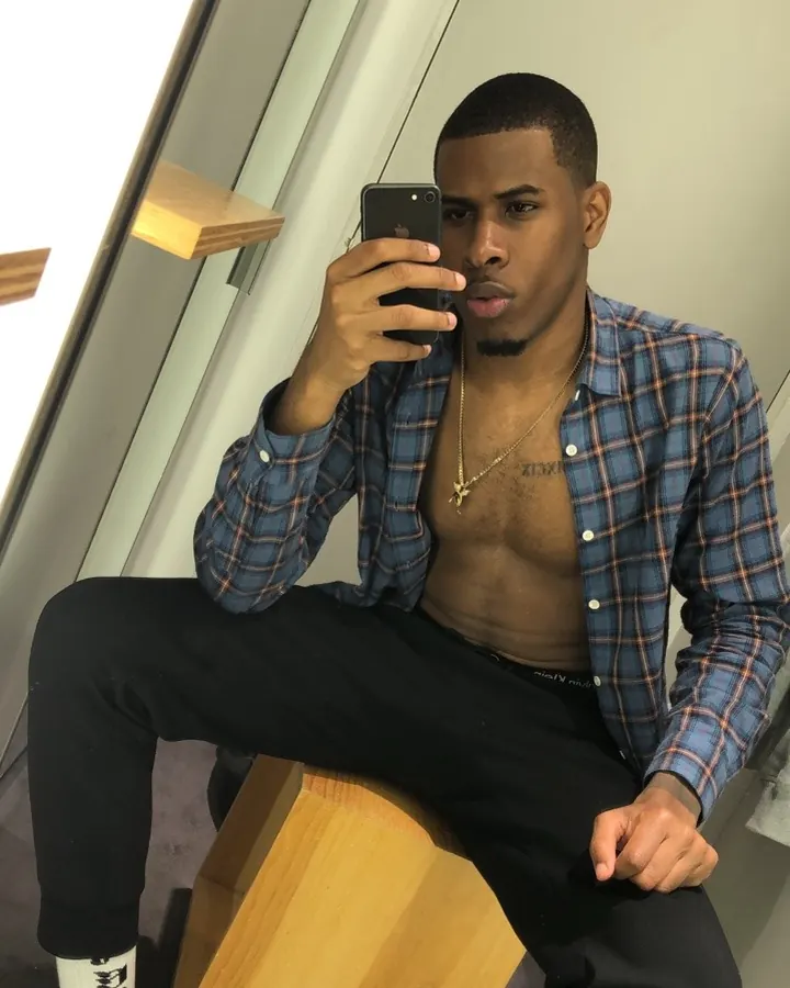 Homme africain torse nu, musclé, en sous-vêtements noirs, posant devant un fond blanc.
